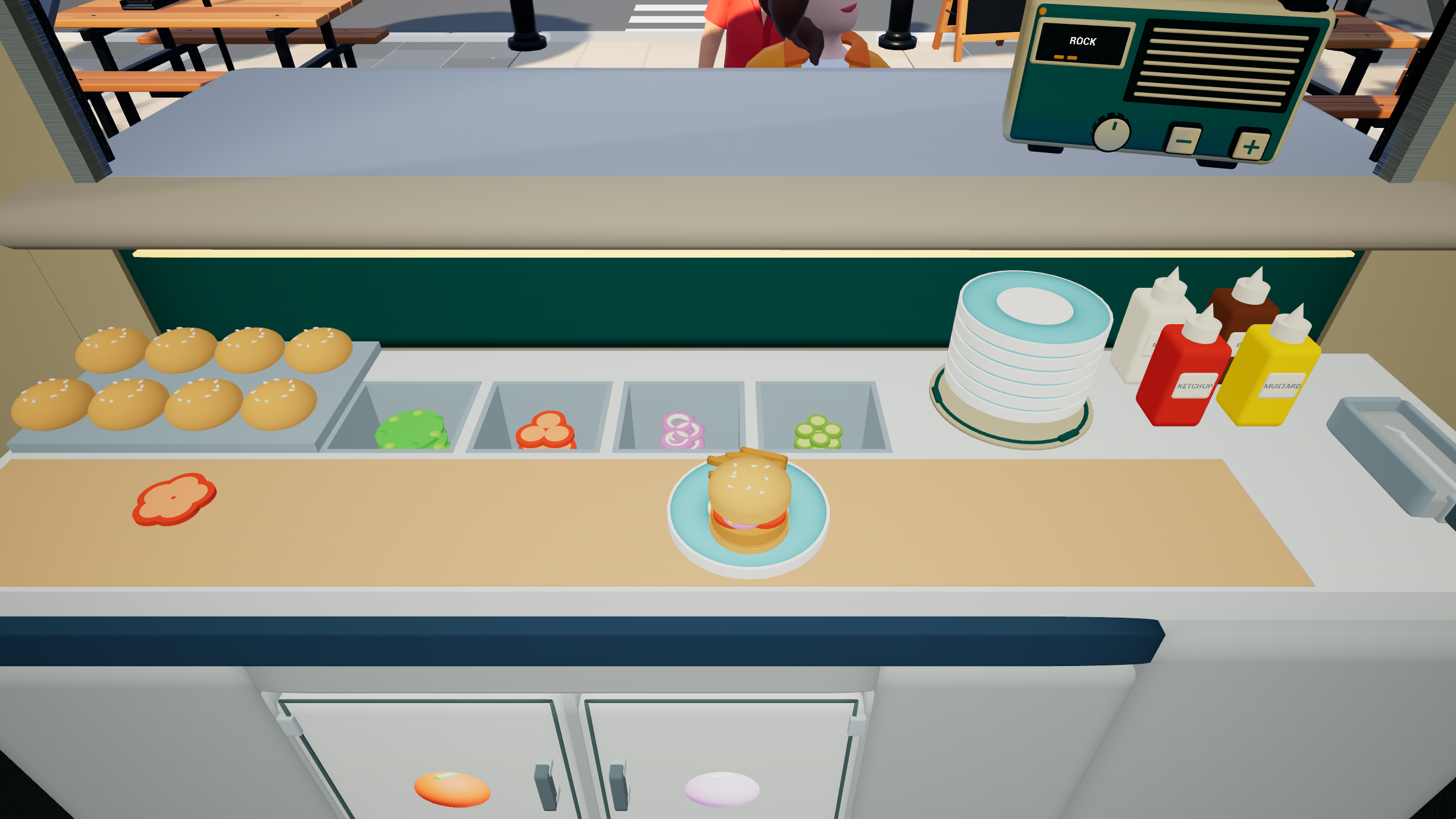 A prepared burger beside buns, vegetables, plates, and sauces at the kitchen worktop